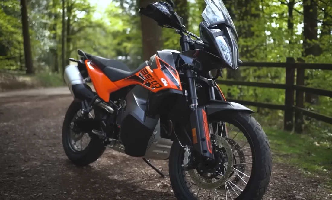 890 Adventure R - black and orange bike standing near wooden fence in the forest