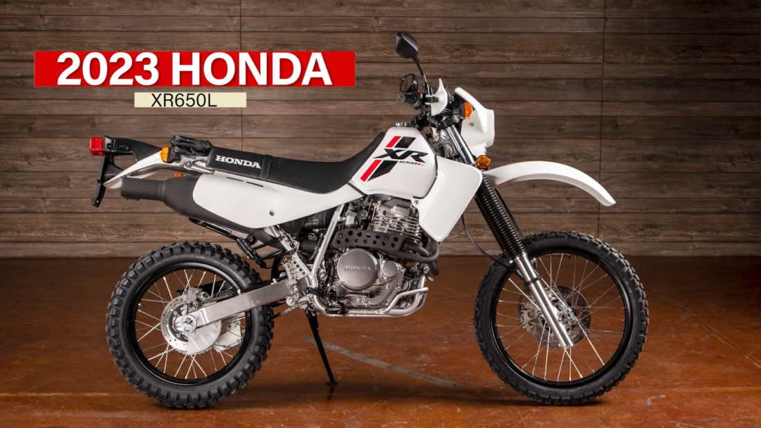 Honda XR650L - white and black bike on brown floor near wooden wall