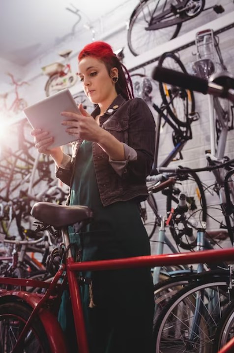 a female mechanic using a digital tablet in a bike shop